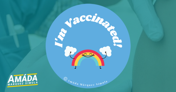 Blue button pin with a smiling rainbow that reads I'm vaccinated!