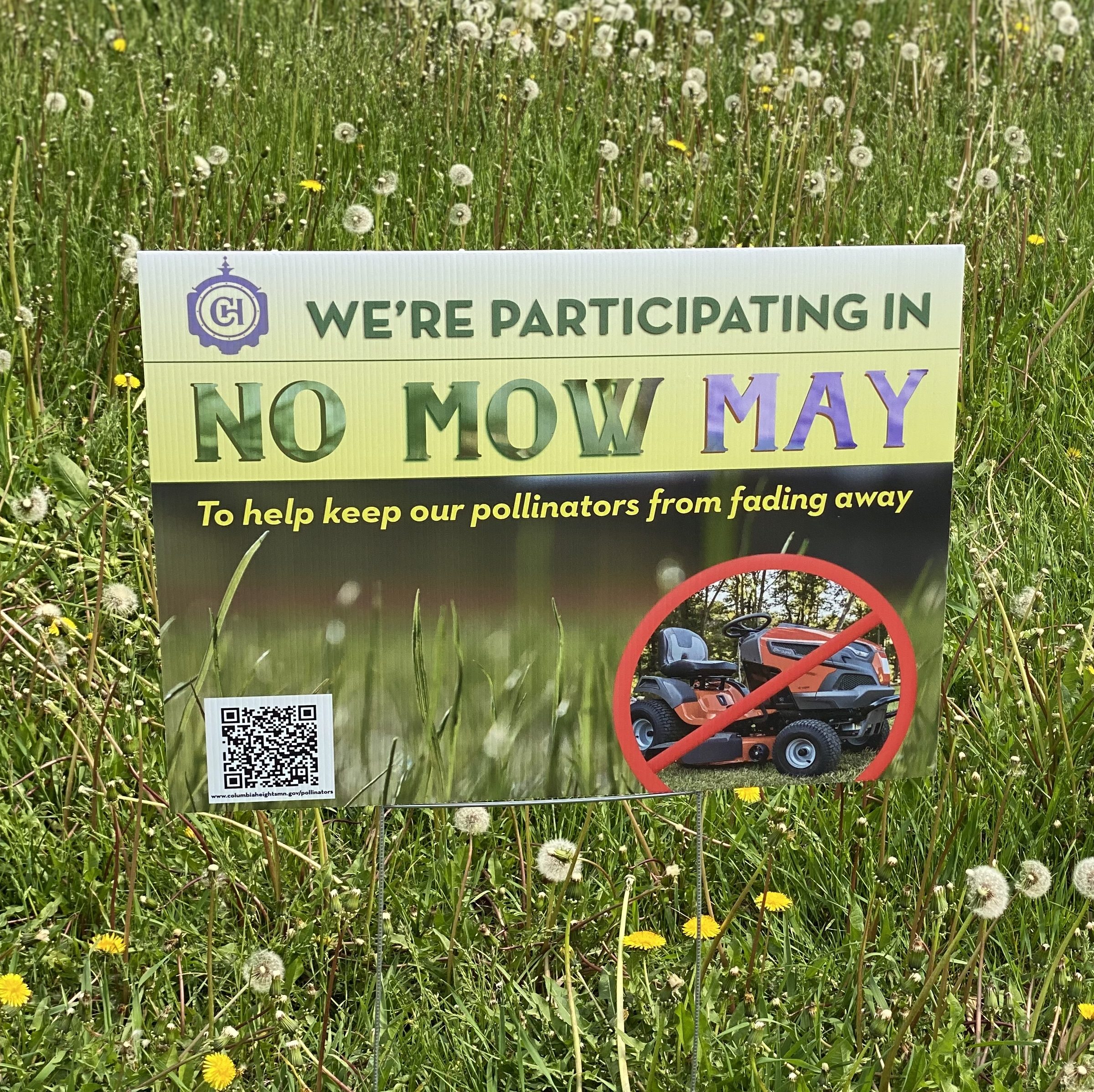 Lawn sign that reads 'We are participating in No Mow May to help keep our pollinators from fading away.'