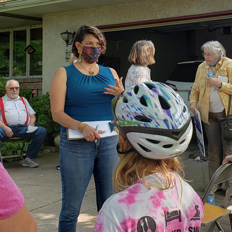 Amáda Márquez Simula talks with Columbia Heights voters at a meet and greet in a residential driveway.