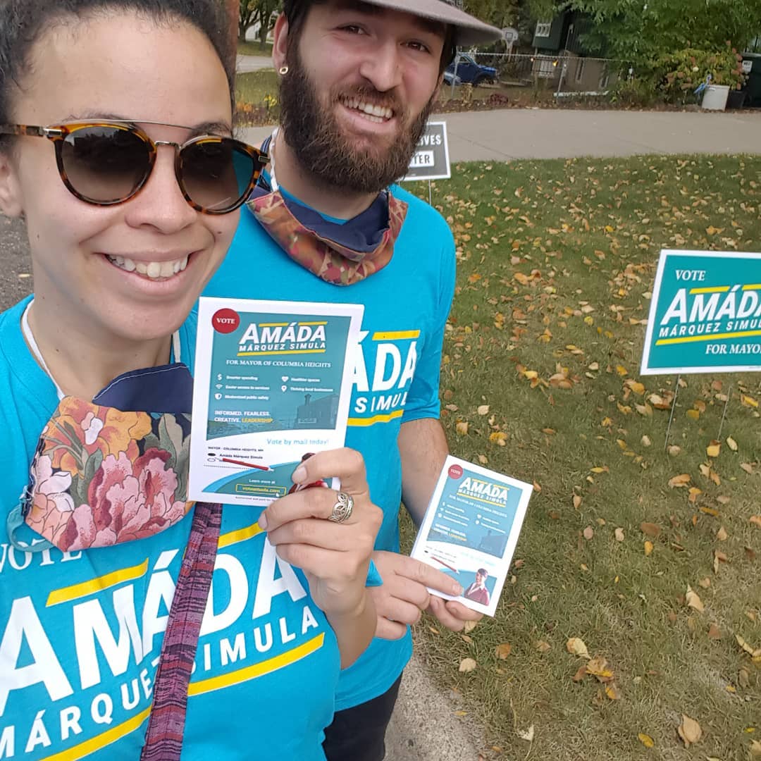 Volunteers for Amáda Márquez Simula wearing campaign T-shirts hold door literature.