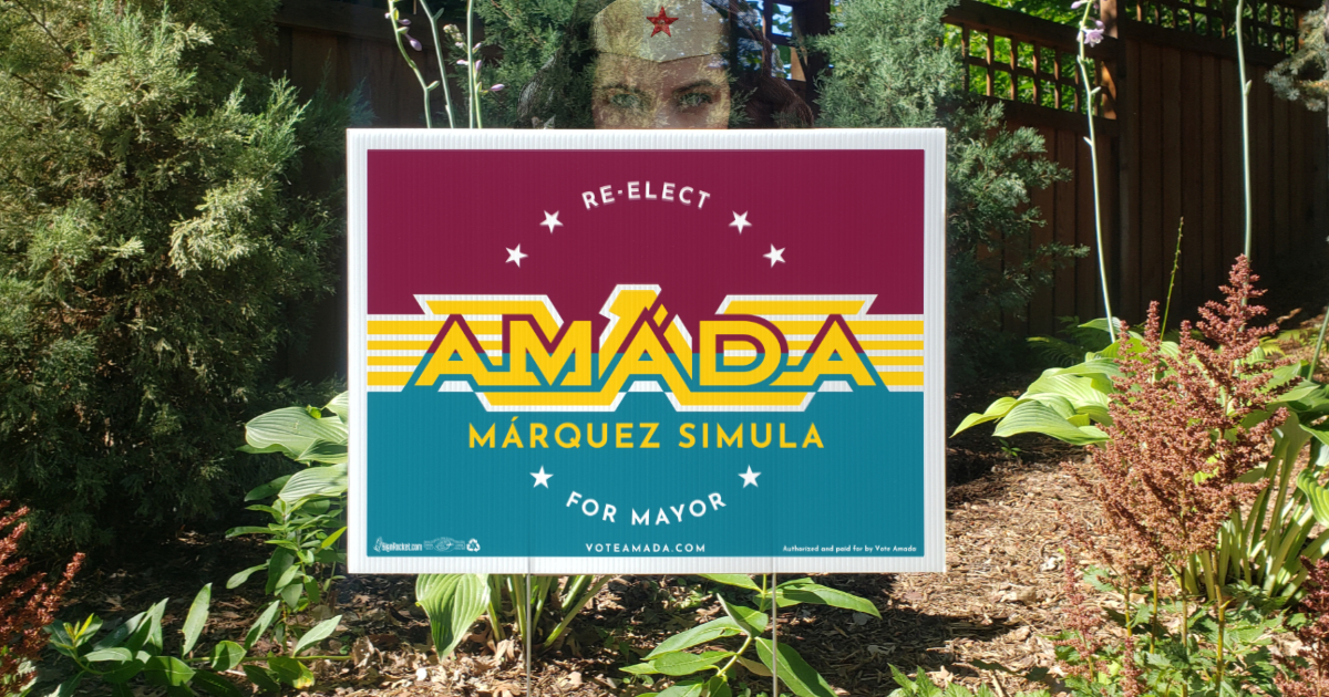 Superheroine themed lawn sign that reads Re-Elect Amáda Márquez Simula for Mayor.