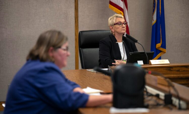 Racist KT Jacobs sits at the dais unfazed by her censure.